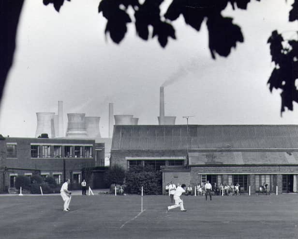 A game of cricket taking place on the sports field for staff at John Waddington's printing factory, off Wakefield Road, Thwaite Gate. The cooling towers of Skelton Grange Power Station can be seen above the rooftops. Waddingtons printing factory was founded in the 1890s and was well known for producing playing cards, theatre bills and board games, especially Monopoly. The factory was demolished around 1992.