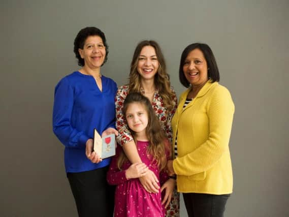 The family of the late Errol James MBE, JP. Left and right daughters Lynne James holding Mr James MBE medal awarded for his work in community and race relations, and Susan Holliday: middle-granddaughter Grace Holliday, front his seven-year-old great-granddaughter Esme Holliday. 
Picture: Paul Floyd Blake.