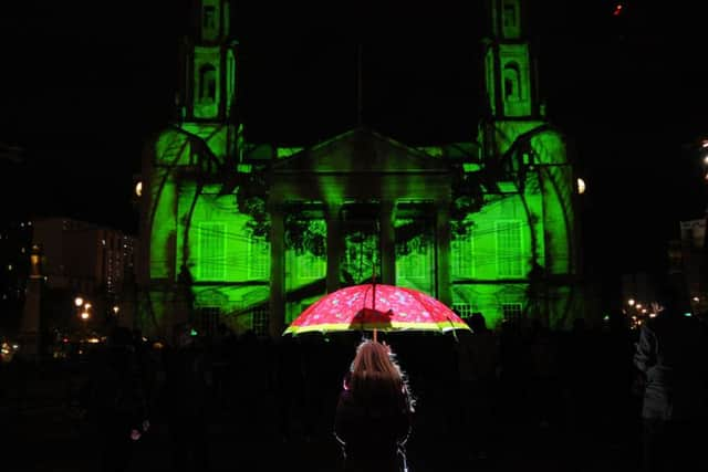 A young girl watches The Phoenix in the Stone on the Civic Hall.