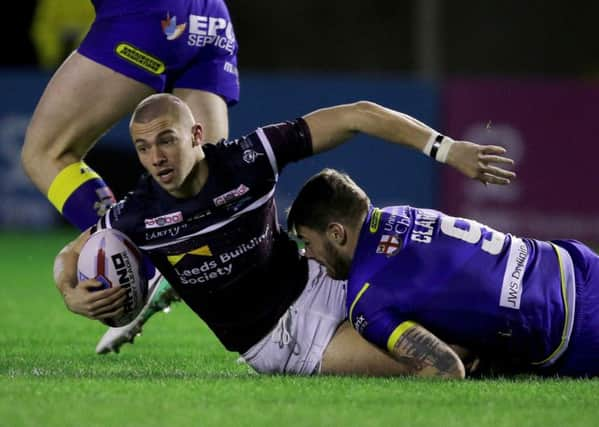 Leeds Rhinos' Jack Walker is tackled by Warrington's Daryl Clark .