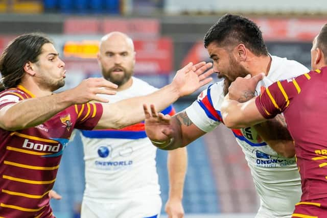 Wakefield's David Fifita fends off Huddersfield's Jake Mamo and Danny Brough.